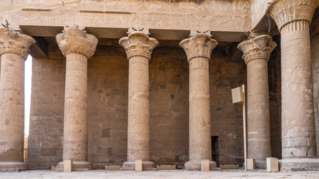 Colonnade in the ancient Egyptian temple of Horus in Edfu. Tall columns and walls are covered with...