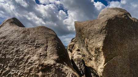 Picturesque whimsical granite rocks against a background of blue sky and clouds. Rough surface texture. Seychellesの写真素材