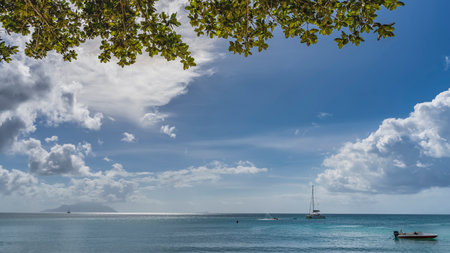 Tropical idyll. Yachts and boats are visible in the calm turquoise ocean. The silhouette of the...