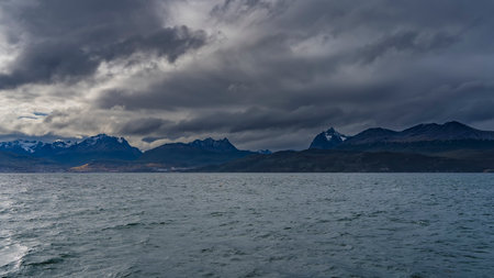 View from the Beagle Canal on the coast of Argentina. The picturesque Andean Martial mountain range against a cloudy sky. Ripples on the water. Tierra del Fuego Archipelago. Ushuaiの写真素材
