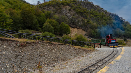 The tourist train of the end of the world Fin del Mundo moves along the historical narrow-gauge...