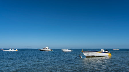 White yachts and motorboats are anchored in the blue ocean. Ripples on the shiny water. Clear azure sky. Copy space.の写真素材