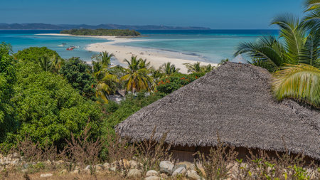 Postcard tropical landscape. A sandbar winds through the aquamarine ocean towards the green island. The boat is at the shore. People on the beach.の写真素材