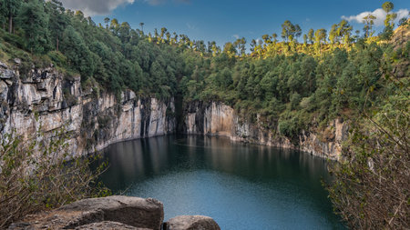 A beautiful alpine emerald lake in the crater of an extinct volcano. Steep rocky shores. There are...
