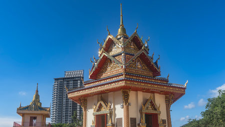 The pagoda of an ancient Burmese Buddhist Temple against the blue sky. The roof has triangular...