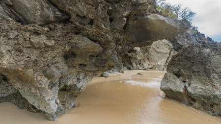 The landscape of the rocky coastline. Picturesque cliffs overhang the sandy beach, forming a stone...