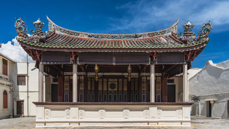 The building of the ancient Chinese theater. A scene with columns. Tiled roof with curved cornice edges and figures of mythical creatures, dragons above. Decorative carved ornamentの写真素材