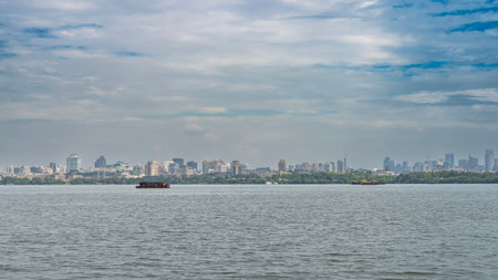 A tourist boat is sailing on a calm lake. Ripples on the water. Green vegetation on the shore....