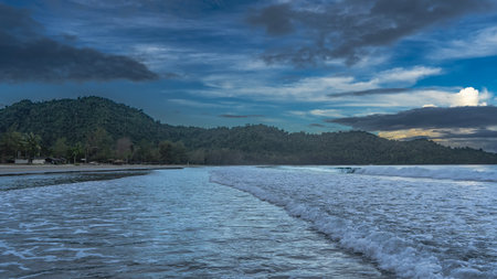 Morning seascape. The ocean waves roll towards the shore, foam, and spread across the beach. The...