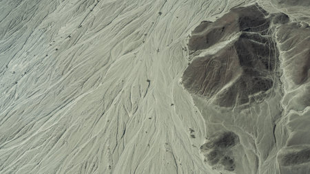 The incredible landscape of the Nazca Desert. There is a huge geoglyph on the cliff face - the figure of an astronaut. Furrows on a sandy plateau. Peru.の写真素材