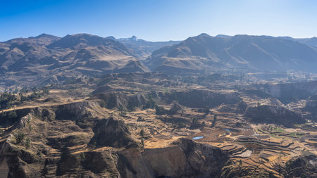 Beautiful mountain landscape. Agricultural terraces, lakes in the valley, and green vegetation are visible on the mountainside. A mountain range against a clear blue sky. Peru.の写真素材