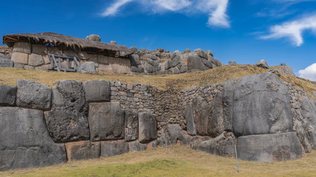 The ancient archaeological complex Sacsayhuaman. Ruins of a Magnificent Inca Fortress. Walls with polygonal ashlar masonry, terraces baluartes. Blue sky, clouds. Peru. Cuscoの写真素材