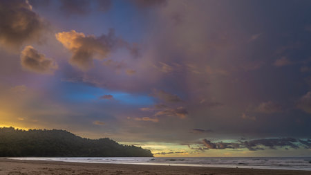 Beautiful evening landscape after sunset. Ocean waves are foaming on a sandy beach. The sky is...