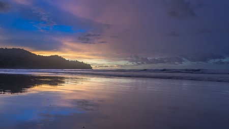 Beautiful colorful sunset by the ocean. Pink clouds in a blue sky. Golden backlight at the horizon....