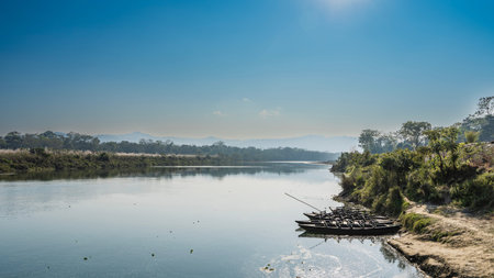 Beautiful calm river in the jungle. Wooden boats near the shore. Green vegetation. Clear blue sky....