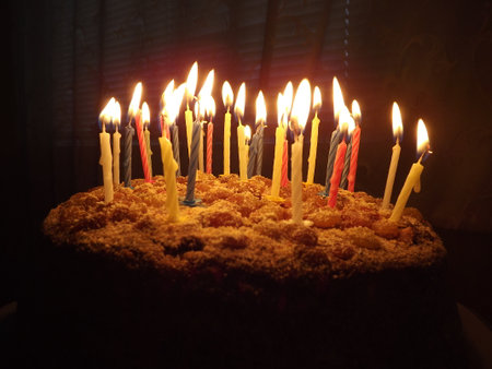 Birthday cake with candles, photographed in the dark. Romance, candle flames.