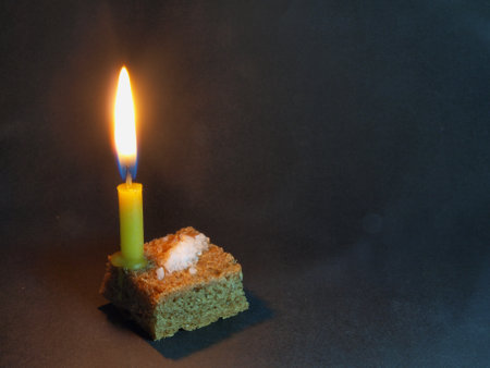 The photo shows Bread, Salt and a lit candle. Beggar's food. Poverty.Lighting and warmth.の写真素材