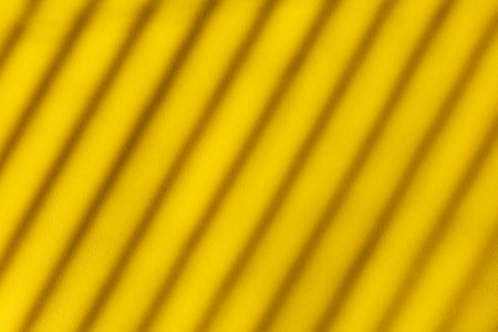 Yellow leather background for design with place for text, pattern of diagonal stripes with light and shadowの写真素材