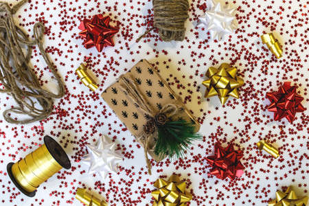 Christmas composition with a gift in a box with pine cones and a branch of a Christmas tree with...