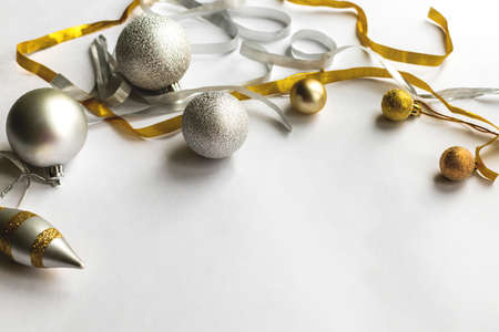 Festive christmas white background with round and conical silver and gold various christmas balls...