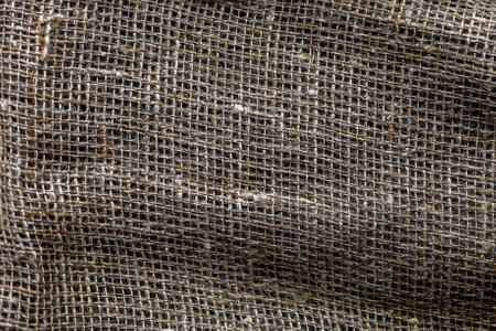 Interesting background design from textured brown coarse fabric of loose square knit, place for text, top viewの写真素材