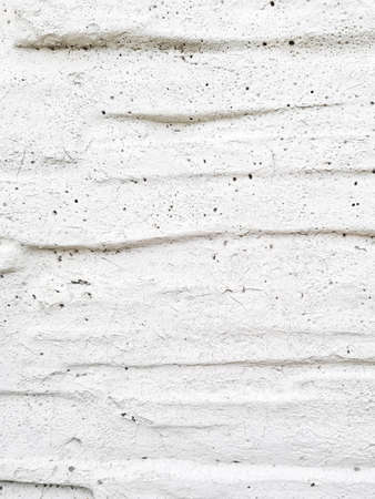 Interesting design of gray textured background from old wall with cracks, scuffs and potholes, vertical arrangement, place for text, close-upの写真素材