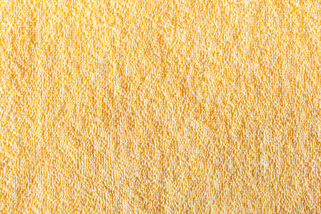 The surface of a bright yellow towel in the form of a beautiful textured abstract backgroundの写真素材
