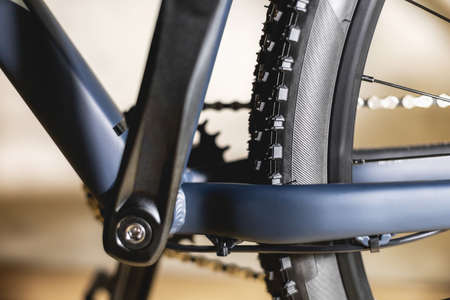 Part of a blue bicycle frame with off-road tires on the rear wheel, with one star on the cranks and...
