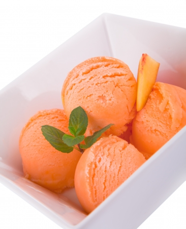 Scoop of yellow ice cream with mint in a bowl の写真素材