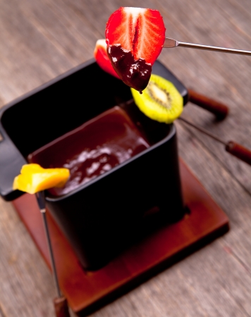 Chocolate fondue with fresh fruits on wood の写真素材