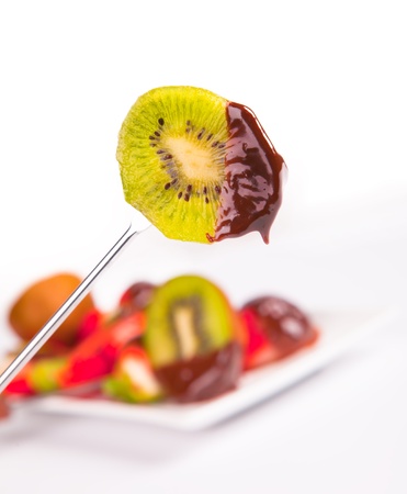 kiwi dipped in chocolate fondue の写真素材