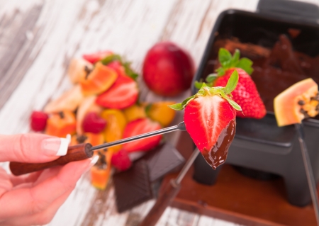 Chocolate fondue with fresh fruits on wood の写真素材