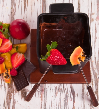 Chocolate fondue with fresh fruits on wood の写真素材