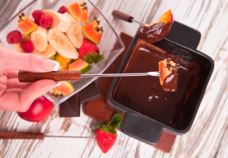 Chocolate fondue with fresh fruits on wood の写真素材