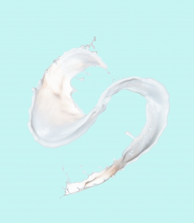 splashing milk isolated on blue backgroundの写真素材