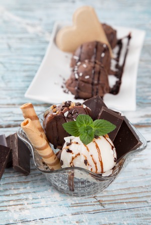 Ice Cream chocolate and vanilla , summer sundae with fresh fruits on wooden background の写真素材