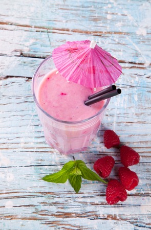 Fresh milk, raspberry drink on wodeen table, assorted protein cocktail with fruits の写真素材