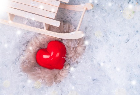 Red heart on a frosty, snow flakes white snow background.の写真素材
