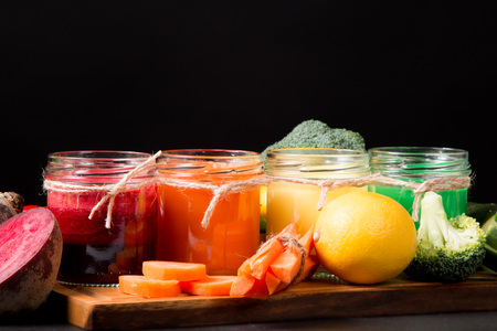Fresh beetroot, lemon, green and carrot smoothie in glass on the black stone. Lifestyle conceptの写真素材
