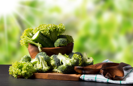 Fresh broccoli on black stone with wooden backgroundの写真素材