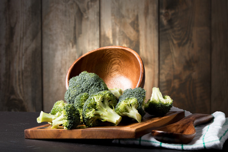 Fresh broccoli on black stone with wooden backgroundの写真素材