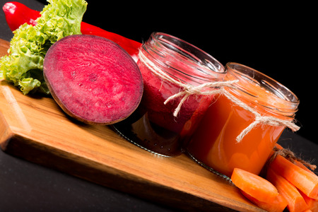 Fresh beetroot and carrot smoothie in glass on the black stone. Lifestyle conceptの写真素材
