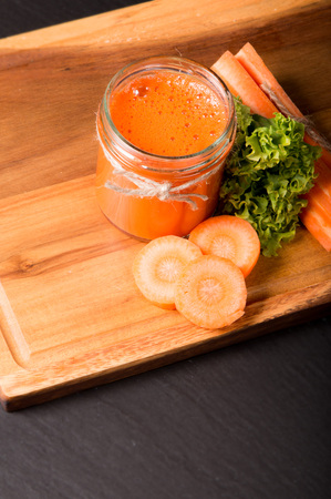 Fresh carrot smoothie in glass on the black stone. Lifestyle conceptの写真素材