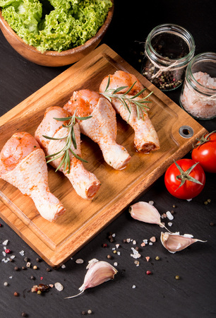 Raw chicken legs on a black stoneの写真素材