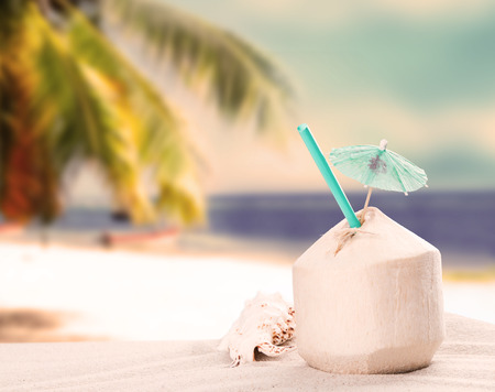Fresh coconut drink on sandy beachの写真素材