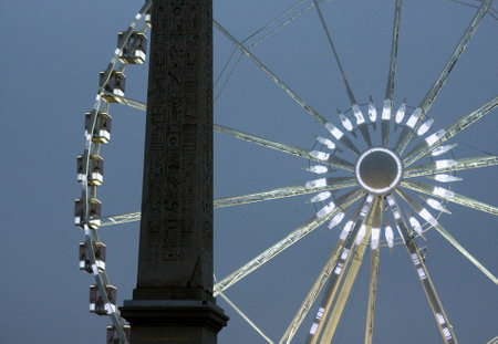 Luxor Obelisk in Paris with a Ferris wheel partially visible. Historical monument, urban setting, and architectural contrast.の写真素材