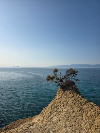 A minimalist view of a clay rock promontory at Canal d'Amour, Corfu, on a clear summer day.
