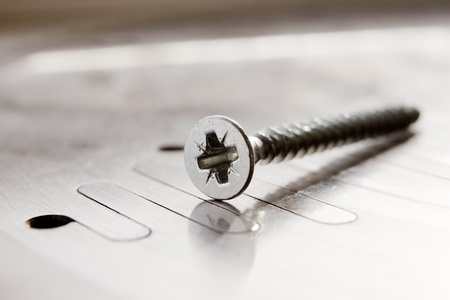 Screw close up on metal plate (shallow depth of field)の写真素材
