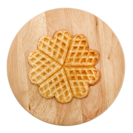 Heart shaped pankake on round wooden board isolated on white backgroundの写真素材