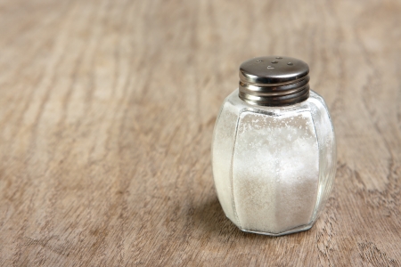Salt shaker on brown wooden tableの写真素材